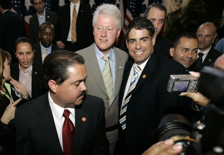 Puerto Rico Sen. Roberto Arango, right, poses for a photo with former U.S. President Bill Clinton, center, after the unveiling ceremony of a statue of former President Franklin D. Roosevelt at the Capitol building in San Juan, on April 7, 2008.